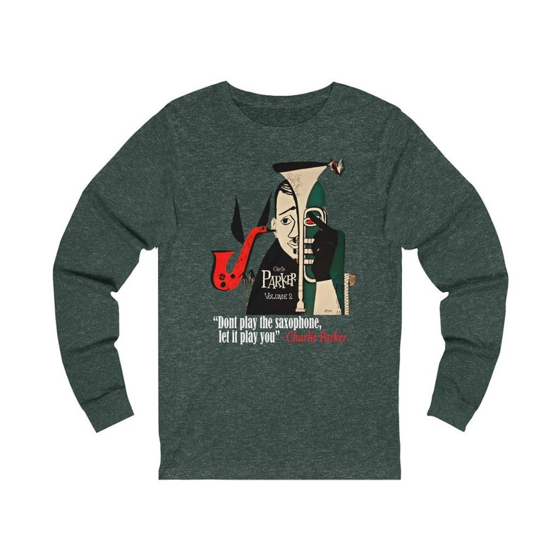 May include: Dark green long-sleeve shirt featuring a stylized illustration of Charlie Parker with a saxophone. The design includes the text "Charlie Parker Volume 2" and a quote: "Don't play the saxophone, let it play you."