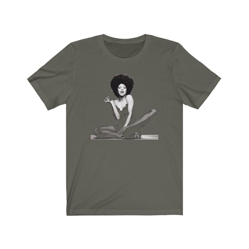 May include: A dark green t-shirt with a black and white image of a woman with an afro sitting with her legs crossed.