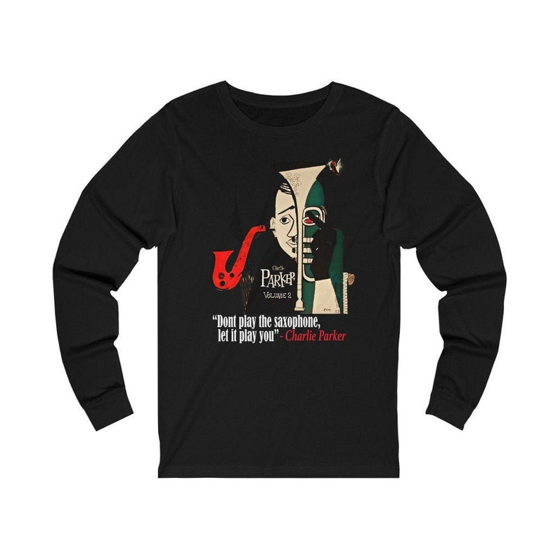 May include: Black long-sleeve shirt featuring a graphic of Charlie Parker with a saxophone. The design includes the text "Don't play the saxophone, let it play you" and "Charlie Parker".