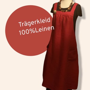 Puede incluir: Un vestido de lino rojo con tirantes y dos bolsillos. El vestido tiene una cintura fruncida y está hecho de 100% lino. El texto "Trägerkleid 100%Leinen" es visible en la imagen.