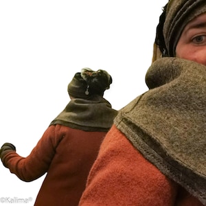 Pode incluir: Uma pessoa vestindo uma blusa cor de ferrugem e um cachecol cinza. A pessoa também está usando um gorro cinza combinando. A imagem é contra um fundo branco.