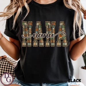 May include: Black t-shirt featuring the word "NANA" in large, patchwork-style letters, with the word "nana" in cursive script underneath. The patchwork design incorporates patterns in brown, green, and orange. The word "BLACK" is printed in the bottom right corner.