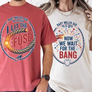 Peut inclure: Deux t-shirts à manches courtes. L'un est rouge avec un graphique d'une mèche allumée et le texte "I LIT THE FUSE". L'autre est blanc cassé avec un graphique de feux d'artifice et le texte "NOW WE WAIT FOR THE BANG". Les deux chemises disent "BABY MILLER DUE 04.12.2026".