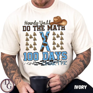 May include: Ivory-colored t-shirt with the text "Howdy Y'all DO THE MATH" and "100 DAYS SMARTER". The design includes a cowboy hat, a large blue and brown "X", and small cowboy figures. A black and white checkered flag is at the bottom.