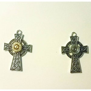 May include: Two silver Celtic cross pendants with a gold bullet casing in the center of each cross.