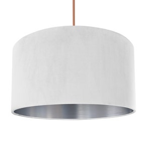 May include: White velvet lampshade with a silver metallic lining. The lampshade is cylindrical and has a smooth, soft texture.