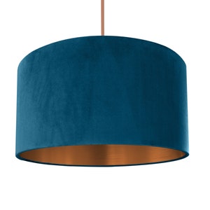 Puede incluir: Una pantalla de l&aacute;mpara de terciopelo azul turquesa con fondo de cobre.