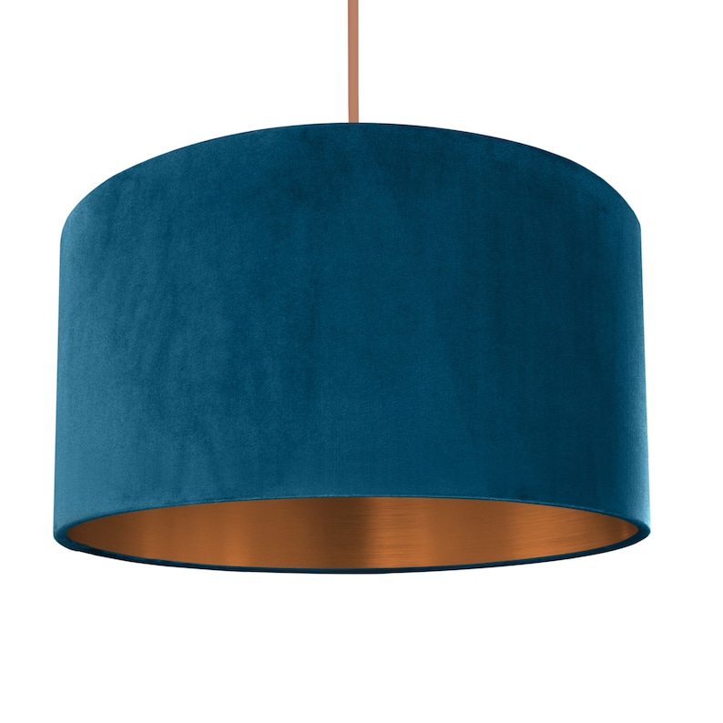 Puede incluir: Una pantalla de l&aacute;mpara de terciopelo azul turquesa con fondo de cobre.