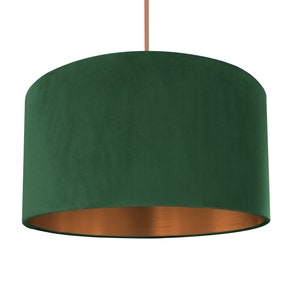 Puede incluir: Una pantalla de l&aacute;mpara de terciopelo verde con fondo de cobre.