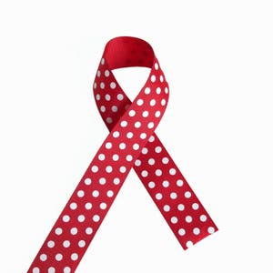 Può includere: Nastro rosso con pois bianchi, legato in un fiocco.
