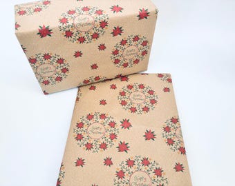 May include: Two sheets of brown wrapping paper with a repeating pattern of red poinsettia wreaths with green vines and the text "Happy Christmas" in a circle.