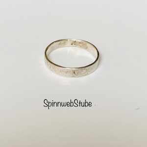 Puede incluir: Un anillo de banda de plata con un acabado texturizado.