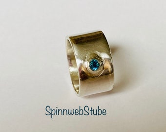 Silver band ring with blue-green zirconia
