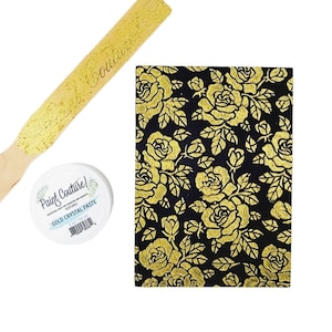 May include: A gold-colored wooden applicator and a jar of gold crystal paste are displayed next to a black surface with a gold rose pattern. The jar is labeled "Paint Couture" and "Gold Crystal Paste."