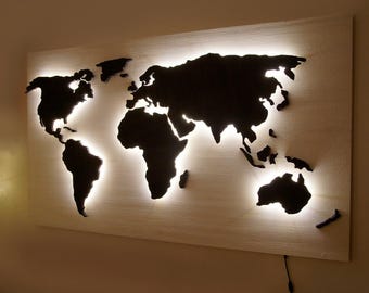 May include: A wooden world map with a white background and black outline. The map is lit from behind with white LED lights.