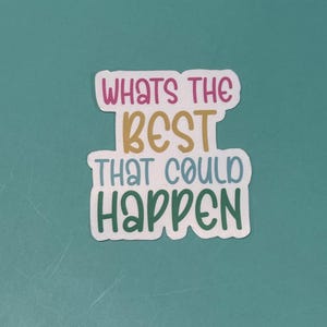 May include: A white sticker with the phrase "WHAT'S THE BEST THAT COULD HAPPEN" in a mix of pink, gold, blue, and green lettering. The sticker is on a teal background.