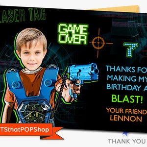 Op de afbeelding: Een bedankkaart met een neon groen en blauw ontwerp. De kaart toont een jongen die een blauwe lasergame-gun vasthoudt en een zwarte vest draagt met een neon groen en blauw ontwerp. De tekst op de kaart luidt "Laser Tag", "Game Over", "Bedankt voor het maken van mijn verjaardag tot een knaller!" en "Je vriend Lennon".
