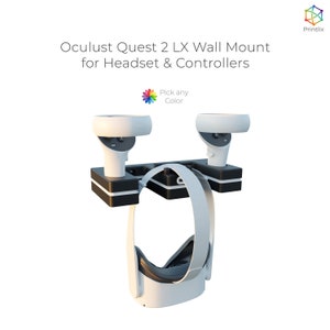 May include: White Oculus Quest 2 VR headset and two controllers mounted on a black wall mount. The mount has a space for the headset and two slots for the controllers.