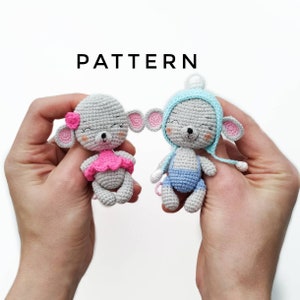 Puede incluir: Dos muñecos de ratón de ganchillo, uno con un vestido y una flor rosas, el otro con un gorro y un peto azules. Los muñecos son grises con orejas rosas y caras sonrientes. La palabra "PATTERN" está encima de los muñecos.