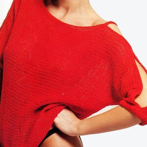 May include: A red knitted jumper with a scoop neck and cut-out shoulders. The jumper is shown on a model wearing a red cap and red earrings. The text "PDF Pattern" is at the bottom of the image.
