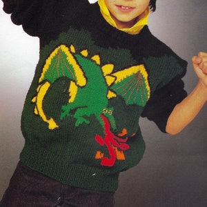 Può includere: Un maglione di lana verde, giallo e rosso con un disegno di drago. Il maglione è indossato da un bambino piccolo con i capelli scuri. Il testo "PDF Pattern" è in fondo all'immagine.