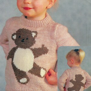 May include: A pink knitted jumper with a brown teddy bear design on the front and back. The jumper has a crew neck and long sleeves. The text "PDF Pattern" is printed at the bottom of the image.