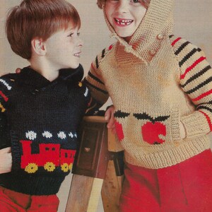 May include: Two children wearing knitted sweaters. The boy is wearing a blue sweater with a red train design. The girl is wearing a beige sweater with a red apple design and a striped hood. The text "PDF Pattern" is at the bottom of the image.