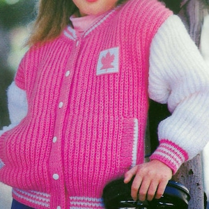 May include: A pink and white knitted cardigan with a maple leaf patch. The cardigan has a button closure and a ribbed texture. The text "PDF Pattern" is printed at the bottom of the image.