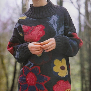 May include: A PDF knitting pattern for a black jumper with a colourful floral design. The jumper has a mock neck and long sleeves. The pattern is available for download.