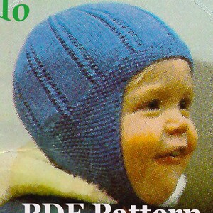 May include: A blue knitted baby hat with a flap that covers the ears. The hat is worn by a baby with a light complexion and blonde hair. The text "PDF Pattern" is printed below the image.