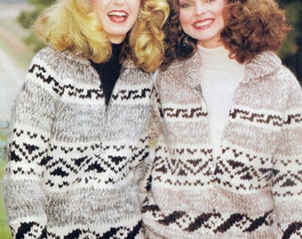 May include: Two women wearing matching zip-up sweaters. The sweaters are a mix of gray, white, and black with a geometric pattern. The sweaters have a collar and a zipper that goes up to the neck. The women are smiling.