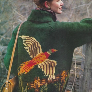 Może przedstawiać: Zielony sweter dzianinowy z wzorem bażanta. Sweter ma wysoki kołnierz i brązowy pasek skórzany. Tekst "PDF Pattern" znajduje się na dole obrazu.