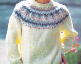 May include: A white knitted sweater with a colorful geometric pattern around the neckline. The sweater has long sleeves and a crew neck.