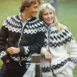 May include: A pair of knitted cardigans with a matching pattern. One is dark brown with white and grey geometric designs, the other is cream-coloured with similar patterns. The sweaters have button closures and are made of a knitted material.