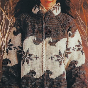 Puede incluir: Un suéter de punto con cremallera marrón, crema y blanco. El suéter presenta un patrón repetido de diseños florales y ondulados estilizados. El cuello y los puños son de color crema más claro, y la cremallera recorre el centro.