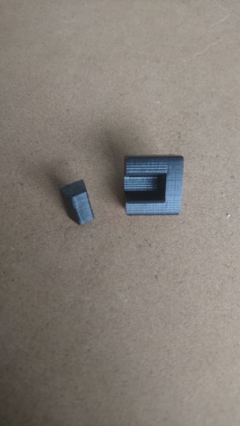 May include: Two small, black, plastic corner pieces. The pieces are designed to be used in a corner of a project.