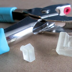 May include: A silver metal punch tool with blue rubber handles and two clear plastic punch inserts.
