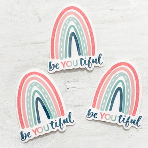 Könnte beinhalten: Drei Regenbogen-Aufkleber mit dem Text "be youtiful" in einem weißen, rosa und blauen Farbschema.