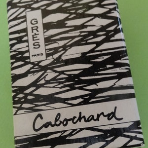 May include: Rectangular box with a black and white abstract design. The box has the words "GRES PARIS" in a vertical white rectangle and the word "Cabochard" in cursive.