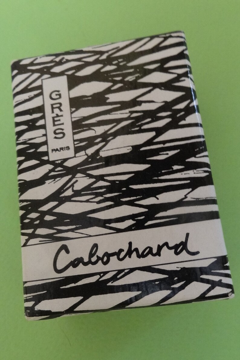 May include: Rectangular box with a black and white abstract design. The box has the words "GRES PARIS" in a vertical white rectangle and the word "Cabochard" in cursive.