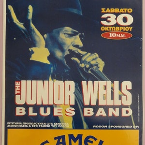 Pode incluir: Um cartaz de concerto para Junior Wells Blues Band, a tocar ao vivo no Rodon em 30 de outubro. O cartaz apresenta uma foto de Junior Wells tocando a gaita, com o texto "Rodon Live!" e "Camel Music" no topo e na parte inferior do cartaz.