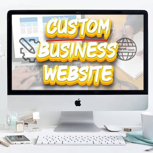 Può includere: Un computer desktop argentato con una tastiera bianca e una tazza bianca su una scrivania bianca. Lo schermo del computer mostra il testo "CUSTOM BUSINESS WEBSITE" in lettere gialle e rosse.