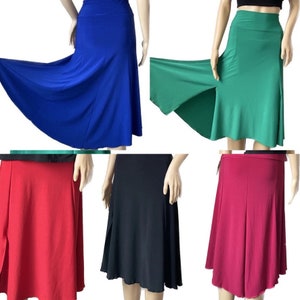 May include: Five different colors of a knee-length, A-line skirt with a side slit. The skirt is made of a stretchy, soft fabric and has a high waist.