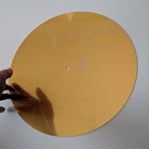 Full size metal replica of NASA Voyager Golden Record cover, laser engraved on aluminium. Celebrate the Voyager missions Glossy with hole