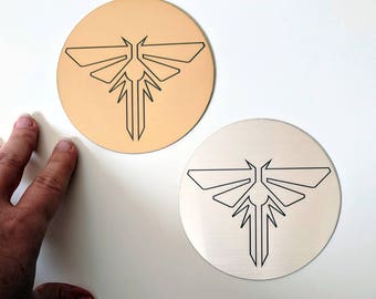 The Last of Us sticker, metallic silver and gold. Fireflies symbol from TLOU and TLOU2, laser engraved. Great for laptops!