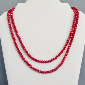 May include: A double strand necklace made of red faceted glass beads.