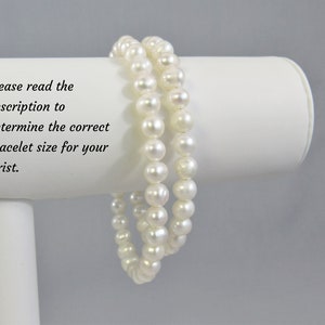 May include: Two white pearl bracelets shown on a white bracelet stans. Please read the description to determine the correct bracelet size for your wrist.