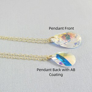 Pu&ograve; includere: Una collana con catena dorata con un ciondolo di cristallo a forma di lacrima. Il ciondolo ha un davanti trasparente e un retro iridescente arcobaleno.
