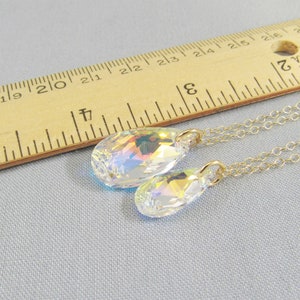 Pu&ograve; includere: Due catene d'oro con ciondoli di cristallo a forma di lacrima. Il ciondolo pi&ugrave; grande &egrave; lungo circa 2,5 cm e il ciondolo pi&ugrave; piccolo &egrave; lungo circa 2 cm.