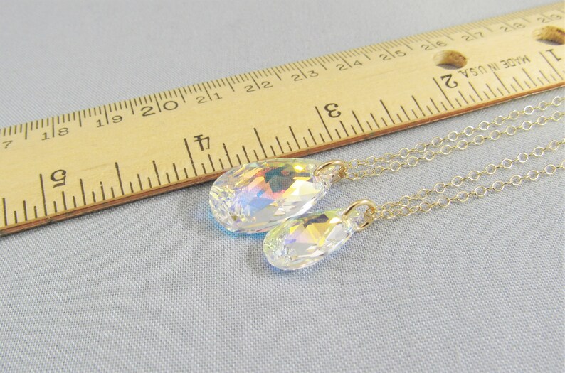 Pu&ograve; includere: Due catene d'oro con ciondoli di cristallo a forma di lacrima. Il ciondolo pi&ugrave; grande &egrave; lungo circa 2,5 cm e il ciondolo pi&ugrave; piccolo &egrave; lungo circa 2 cm.
